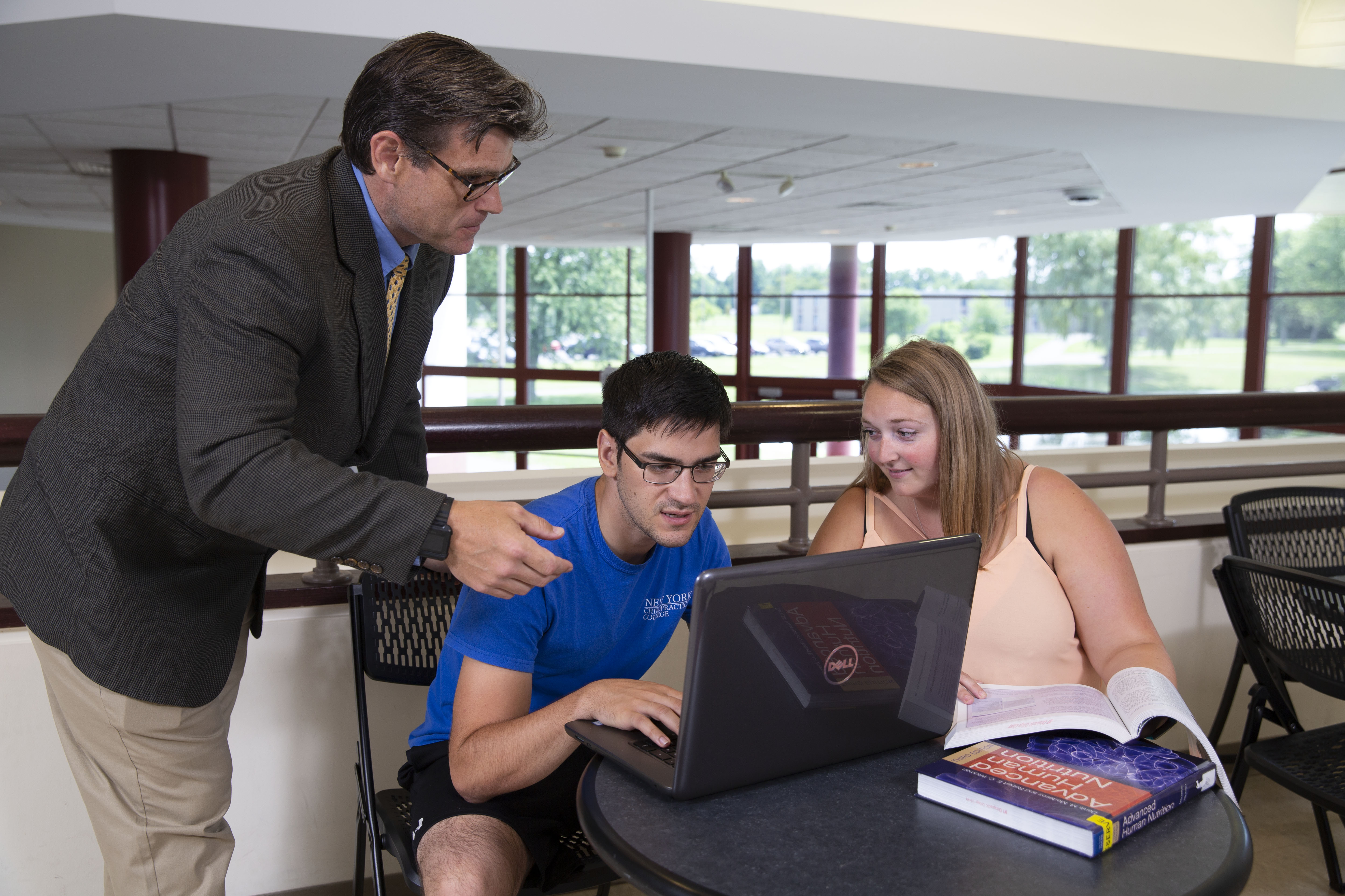 a professor going over coursework with students in a classroom