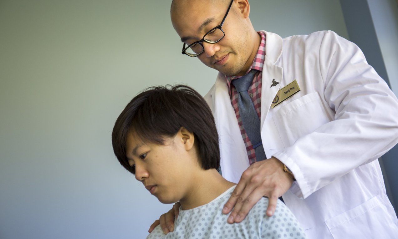 clinician wearing white coat working with a patient