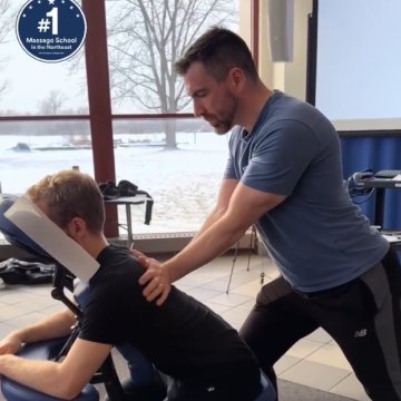 Massage therapy student giving a massage at a clinic event