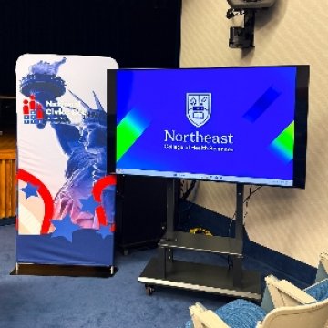 A television with the Northeast College of Health Sciences logo and a stand up graphic for the Western New York Regional Finals of the National Civics Bee