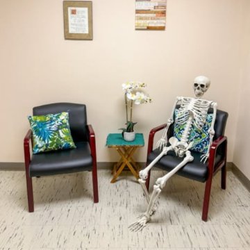 Two chairs on Seneca Falls Campus, one which has a fake skeleton sitting in it.