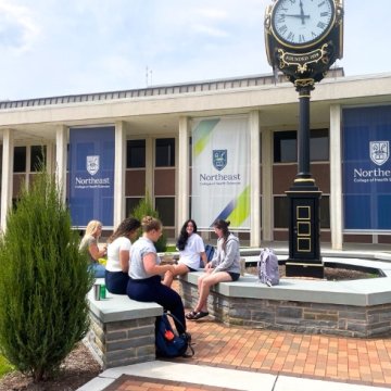 Students hanging out by the clock on Seneca Falls campus
