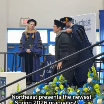 A graduate receiving their hood on stage at Northeast College of Health Sciences' Spring 2026 commencement ceremony.