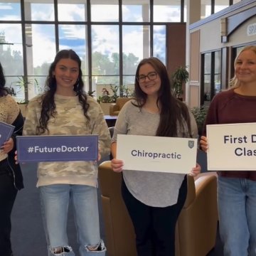 Four students in a campus common area holding signs reading "#FutureDoctor," "Chiropractic," and "First D[ay of] Clas[s]," with text overhead reading "#NortheastBlue students are b[ack]."