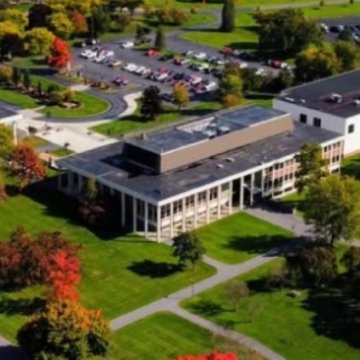 Aerial view of the Northeast College of Health Sciences campus surrounded by colorful fall trees and green lawns.