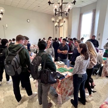A ground of students gathered around a table