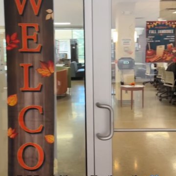A fall-themed “Welcome” banner hanging on a campus door with a “Fall Jamboree” sign visible inside, captioned “Fall Festivities at Northeast!”