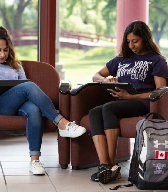 two students sitting and studying on campus at Northeast College of Health Sciences