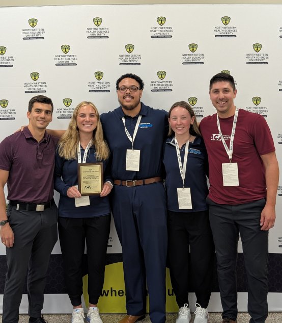 Four students posing with their Student Chapter of the Year award and Dr. Balseca