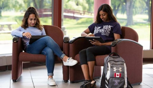 two students sitting and studying on campus at Northeast College of Health Sciences