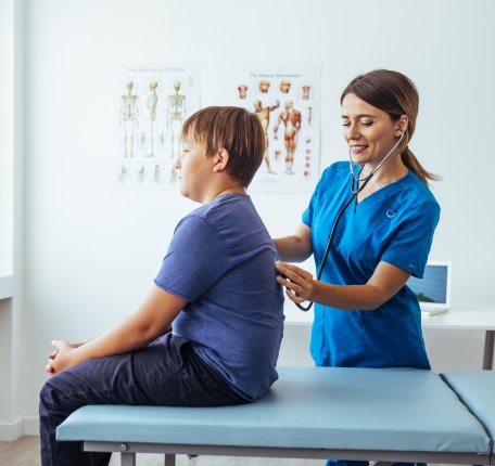 Physician assistant working with a patient who is sitting on a table
