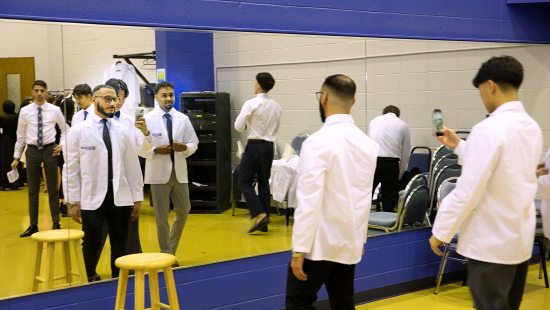 7th Trimester students posing for photos in their white coats at Transitions Ceremony