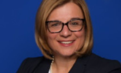 Headshot of alumna Dr. Kristina Petrocco-Napuli (D.C. ’03) in front of a blue background